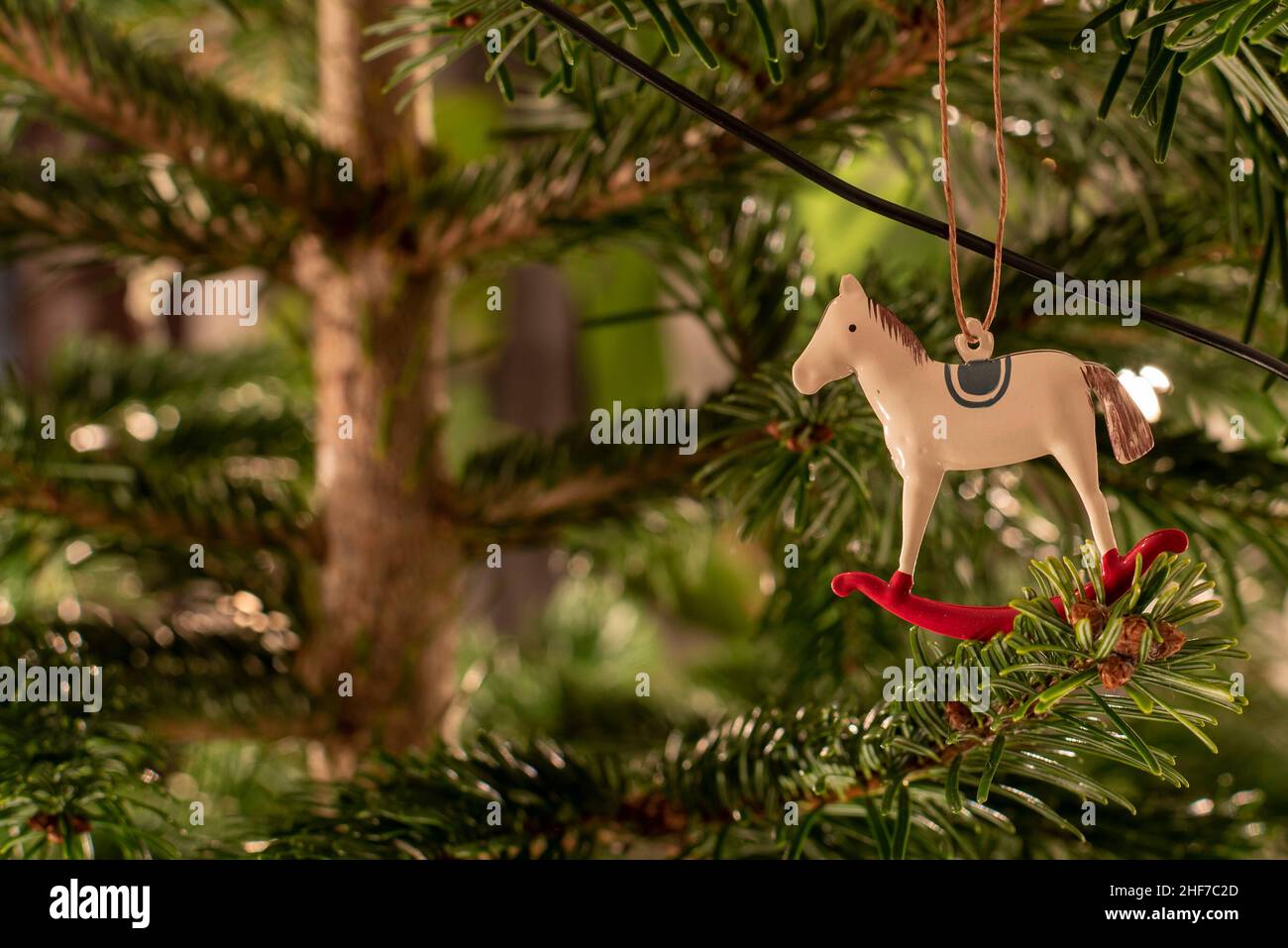 Un cavallo di metallo è appeso su un albero di Natale. Foto Stock