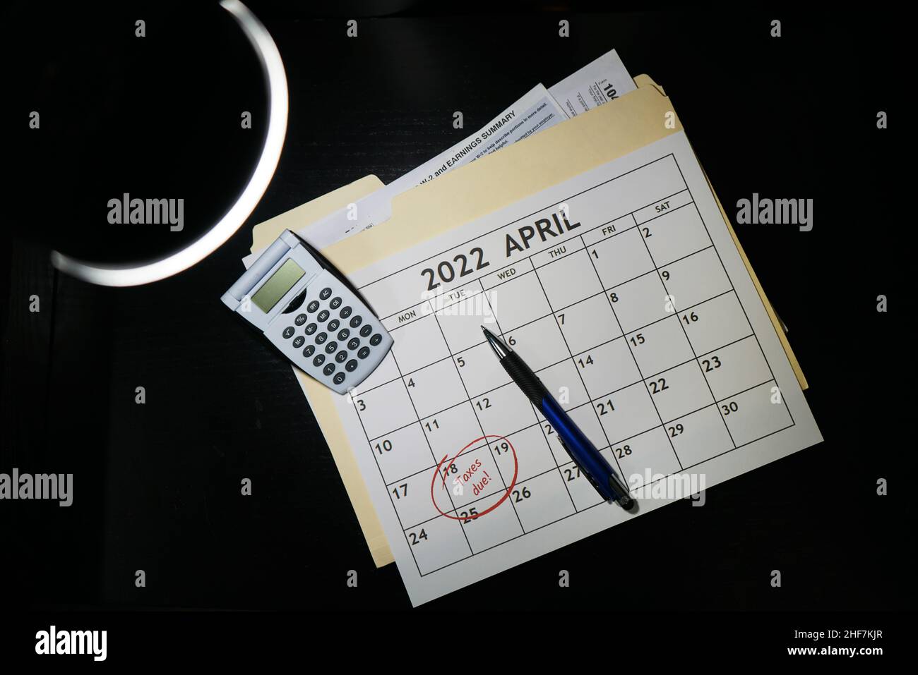 Concetto di 2021 documenti di preparazione fiscale e un calendario con aprile 18th cerchiò le parole tasse due cerchiate in rosso. Su sfondo nero. Foto Stock