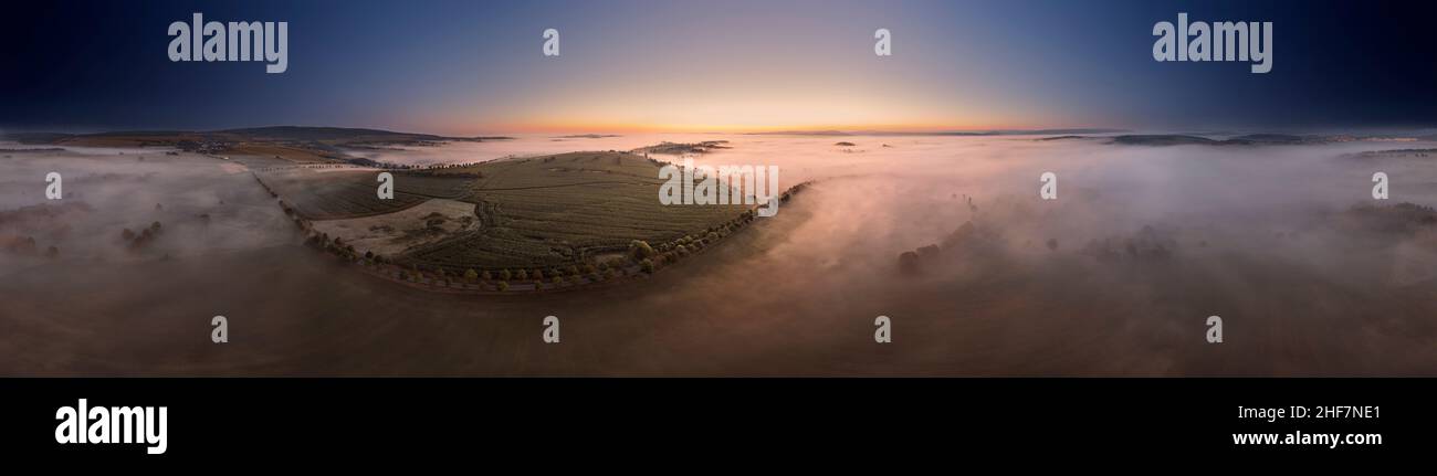 Germania, Turingia, Großbreitenbach, Böhlen, un viale e colline e montagne isolate sporgono da un mare di nebbia, campi, alba, vista aerea, panorama a 360° Foto Stock