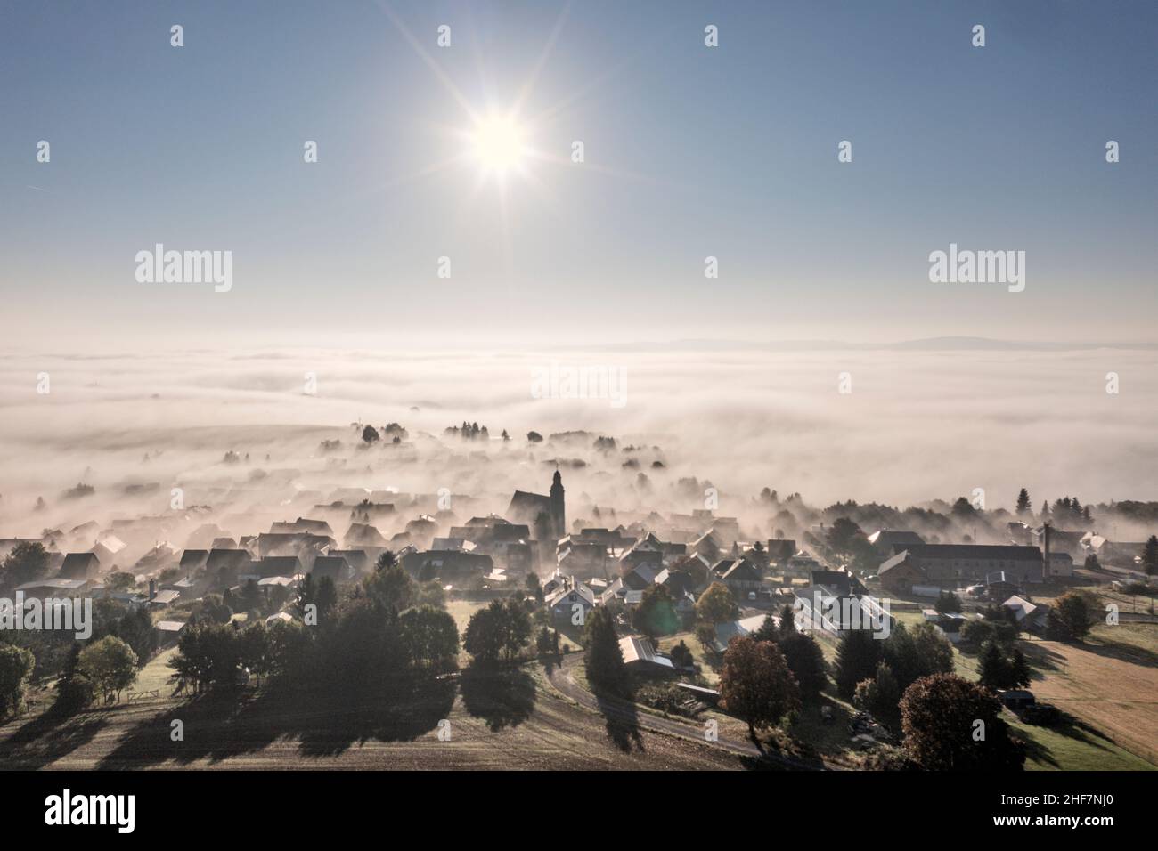 Germania, Turingia, Großbreitenbach, Herschdorf, villaggio, la chiesa sporge dalla nebbia del suolo, dal sole, dalla luce posteriore Foto Stock