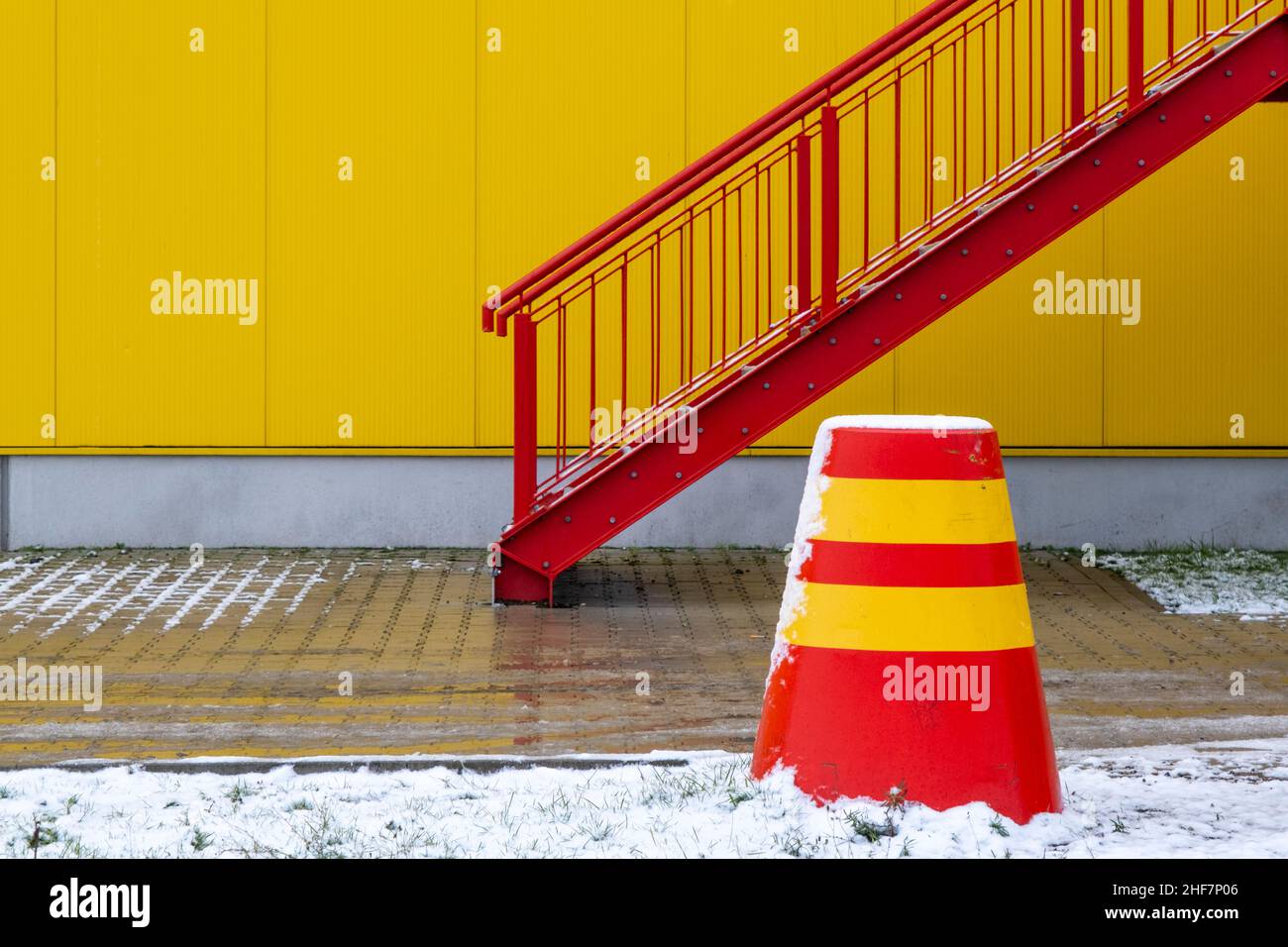 scale rosse, parete gialla, neve, paletto giallo rosso Foto Stock