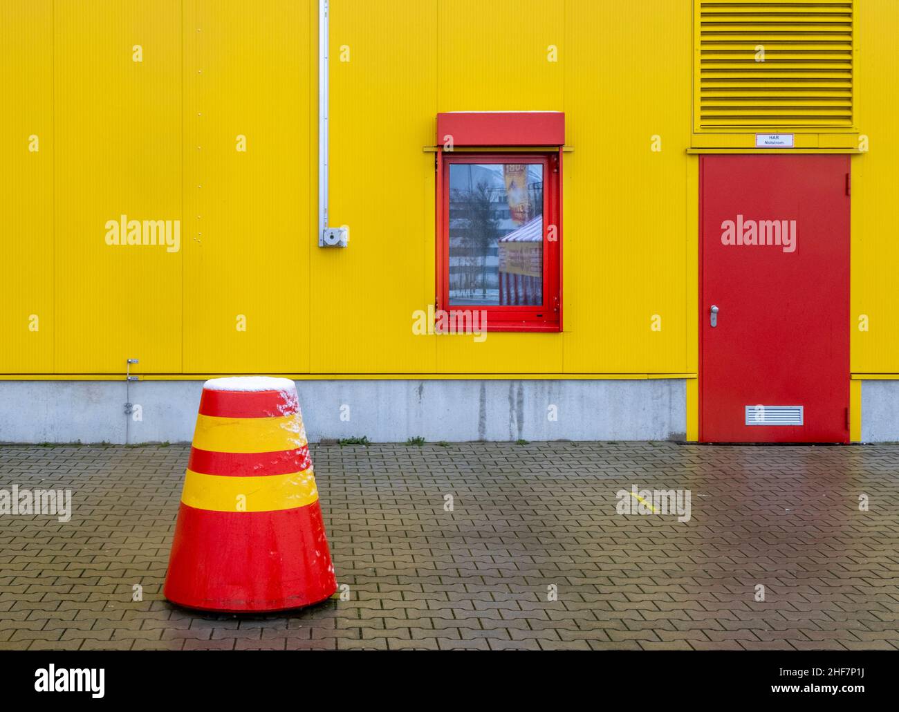 scooter rosso giallo, neve, porta rossa, magazzino giallo Foto Stock