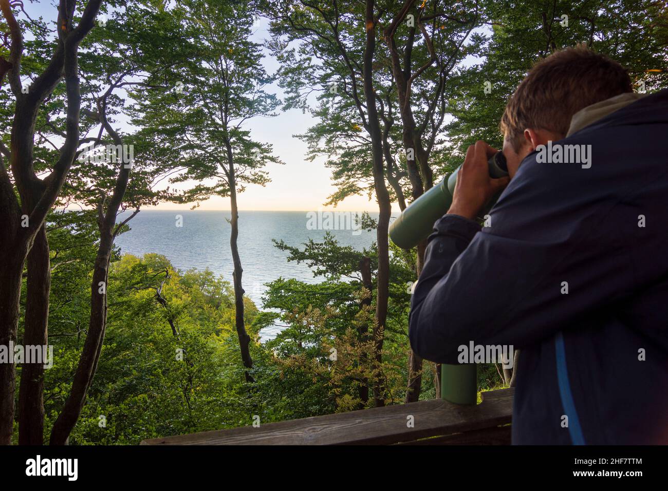 Vordingborg, giovane uomo guarda con telescopio al Mar Baltico a Moens Klint, Moen, Danimarca Foto Stock