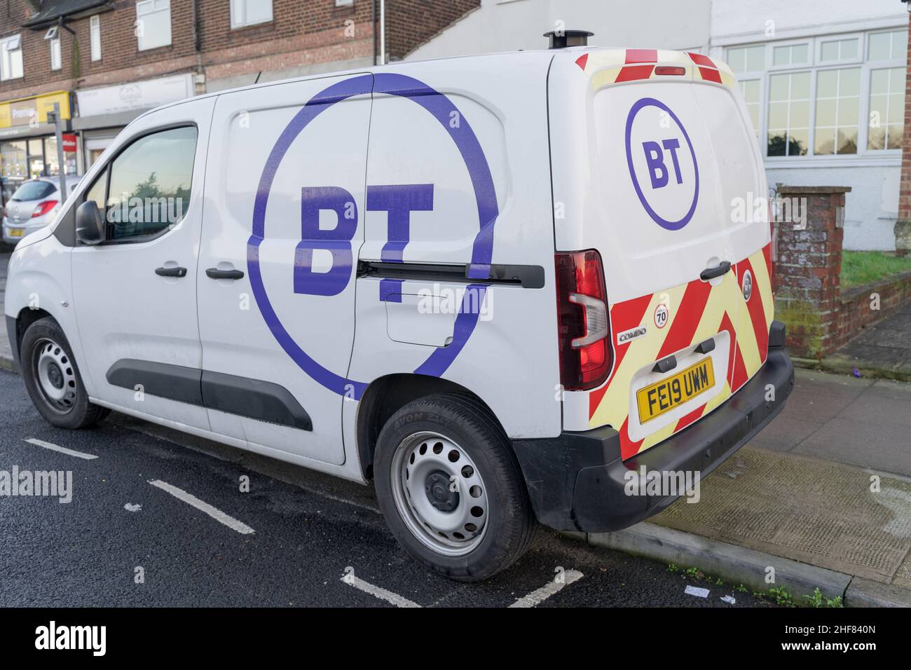 Vista posteriore di tre quarti dei parchi di furgoni bianchi BT sul lato della strada, stampati con il logo del cerchio viola in Inghilterra Regno Unito Foto Stock