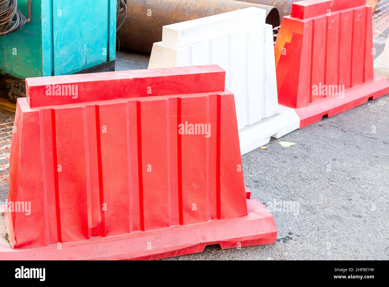 Barriere stradali in plastica rossa e bianca, recinzione stradale sulla strada della città. Strada in costruzione Foto Stock
