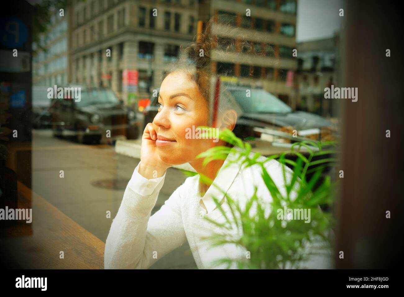 Ritratto di una donna che guarda attraverso una finestra in un caffè . Foto di alta qualità Foto Stock