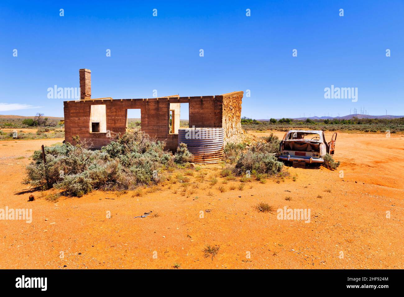 Rovine di vecchia casa storica in pietra di mattoni con il relitto di vecchia auto rustica nella città di Silverton dell'entroterra australiano. Foto Stock