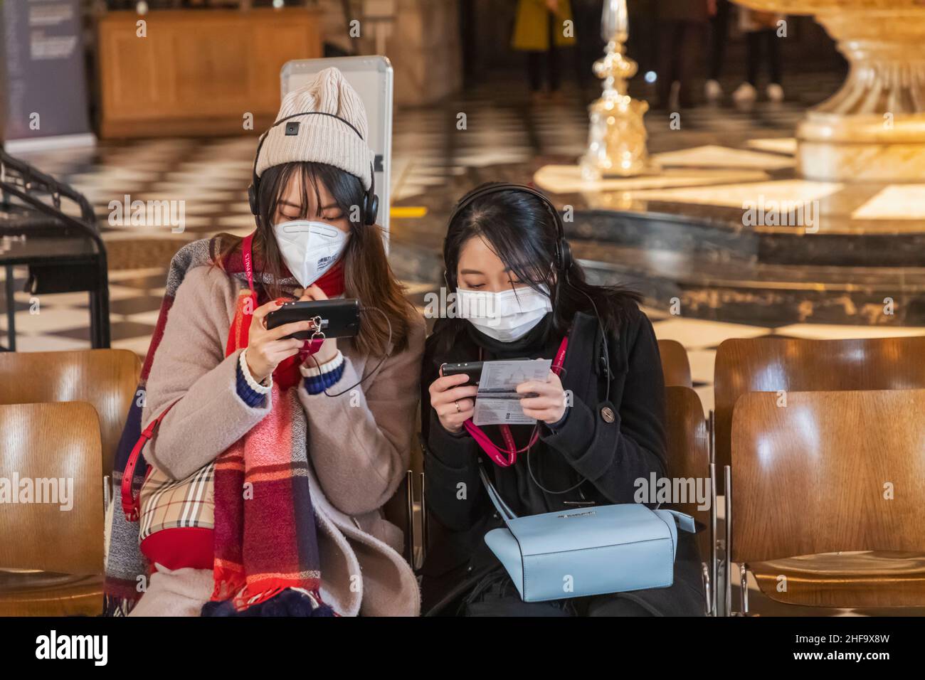 Inghilterra, Londra, Cattedrale di St. Paul, due turisti asiatici che indossano maschere facciali che guardano le Guide audio Foto Stock