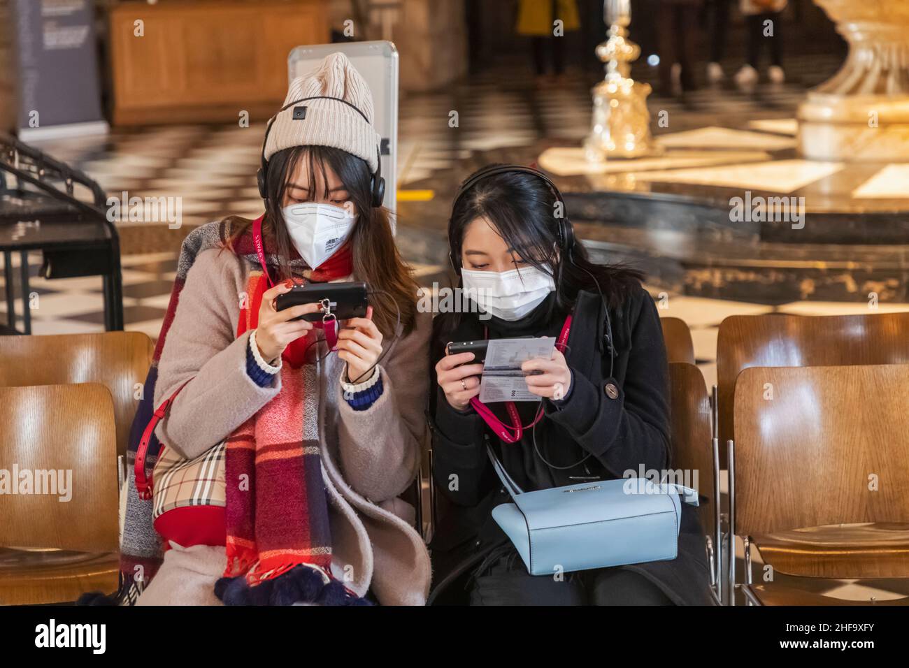 Inghilterra, Londra, Cattedrale di St. Paul, due turisti asiatici che indossano maschere facciali che guardano le Guide audio Foto Stock