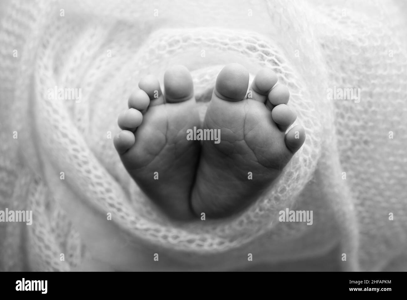 Il piede piccolo di un neonato. Piedi morbidi di un neonato in una coperta. Primo piano di dita del piede, tacchi e piedi di un neonato. Foto Stock