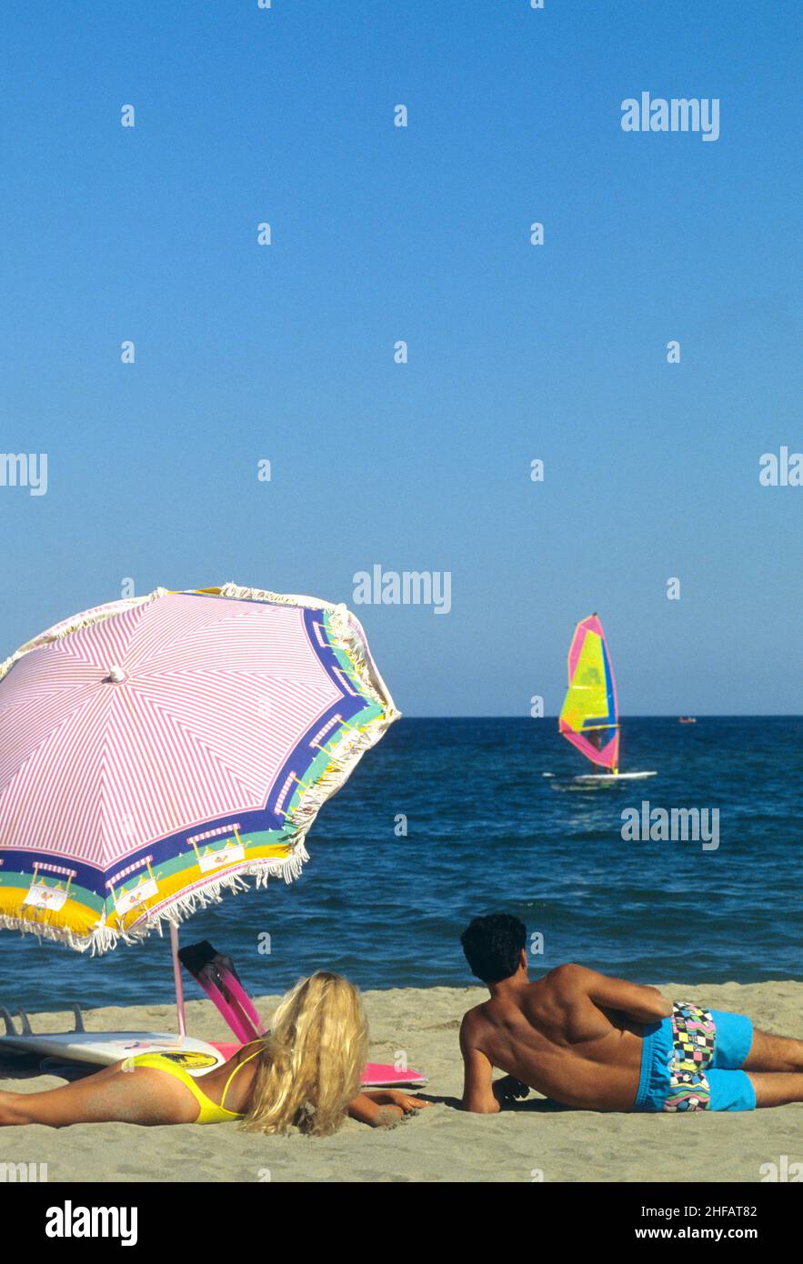 giovani coppie amanti della vista sul retro sulla spiaggia che guardano all'orizzonte sullo sfondo blu del cielo Foto Stock