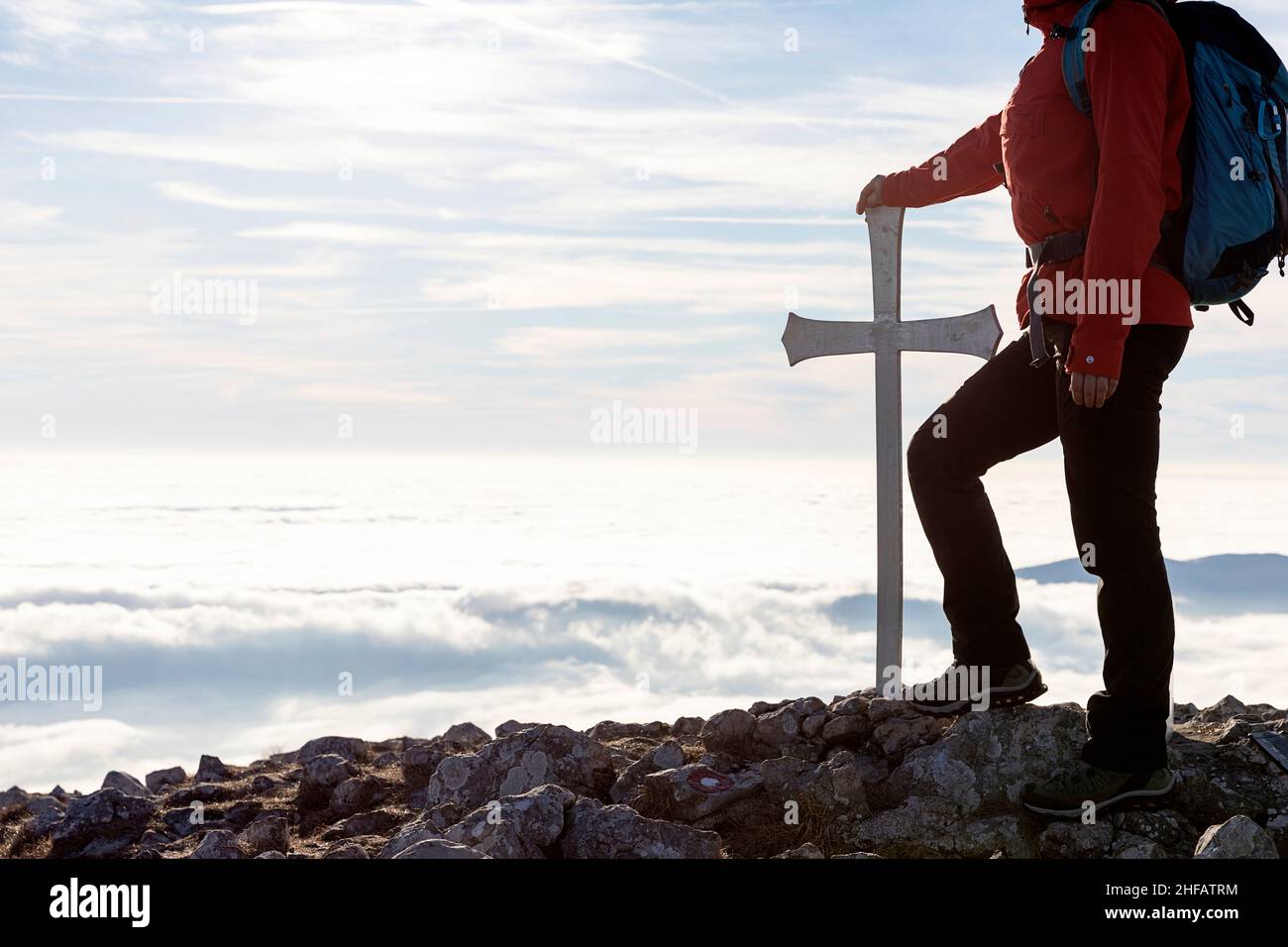 Donna in piedi a croce sulla cima del monte Kucelj, Slovenia Foto Stock