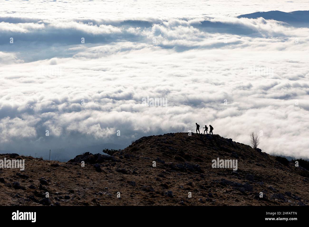 Silhouette escursionista sulla cima del monte Kucelj, sopra la nebbia nella valle di Vipava, Slovenia Foto Stock
