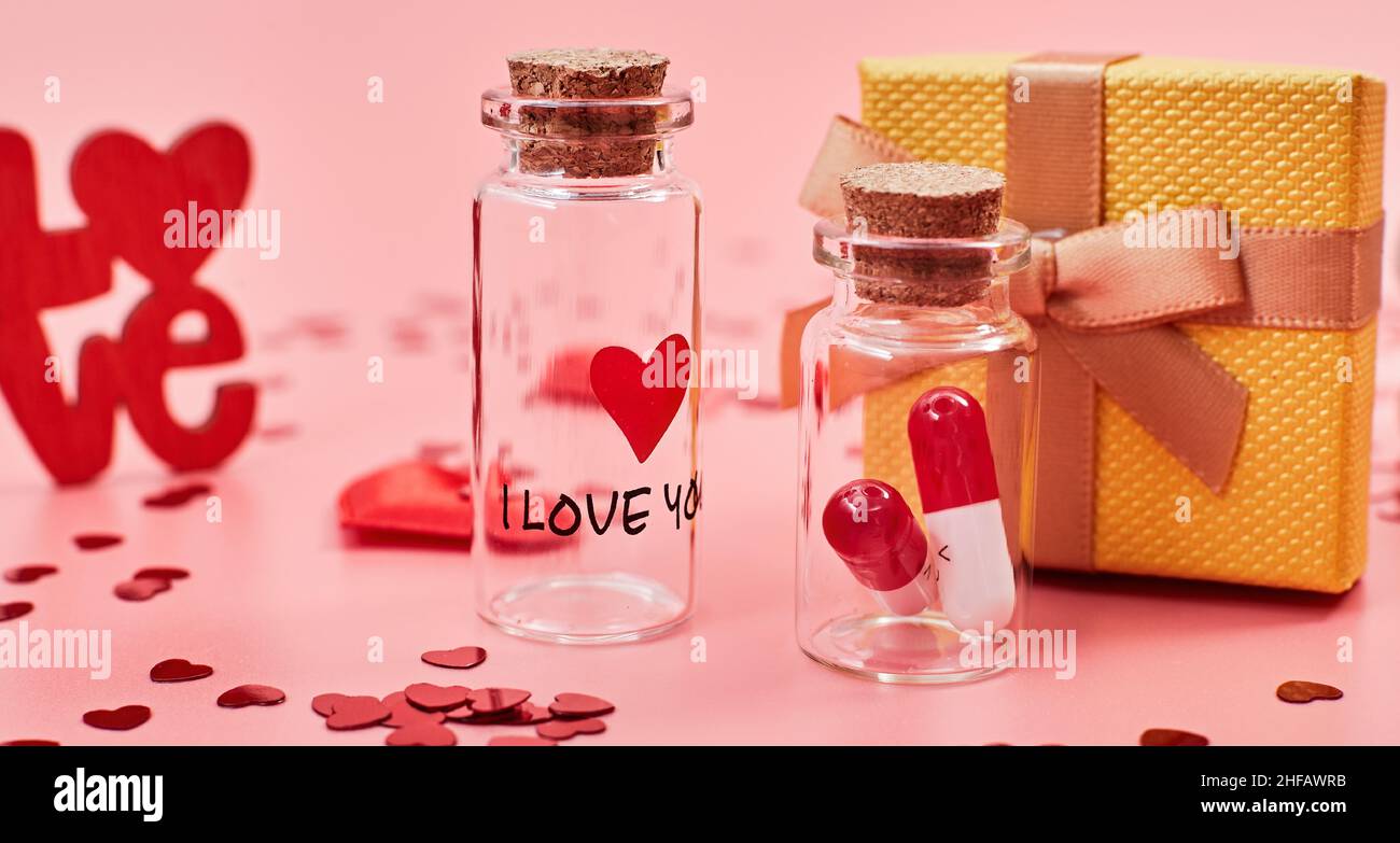 La medicina dell'amore. Le orate di Ti voglio bene. in vaso baciano San Valentino. Amore sfondo. Doni in forma di cuori su sfondo rosa con gli INS Foto Stock
