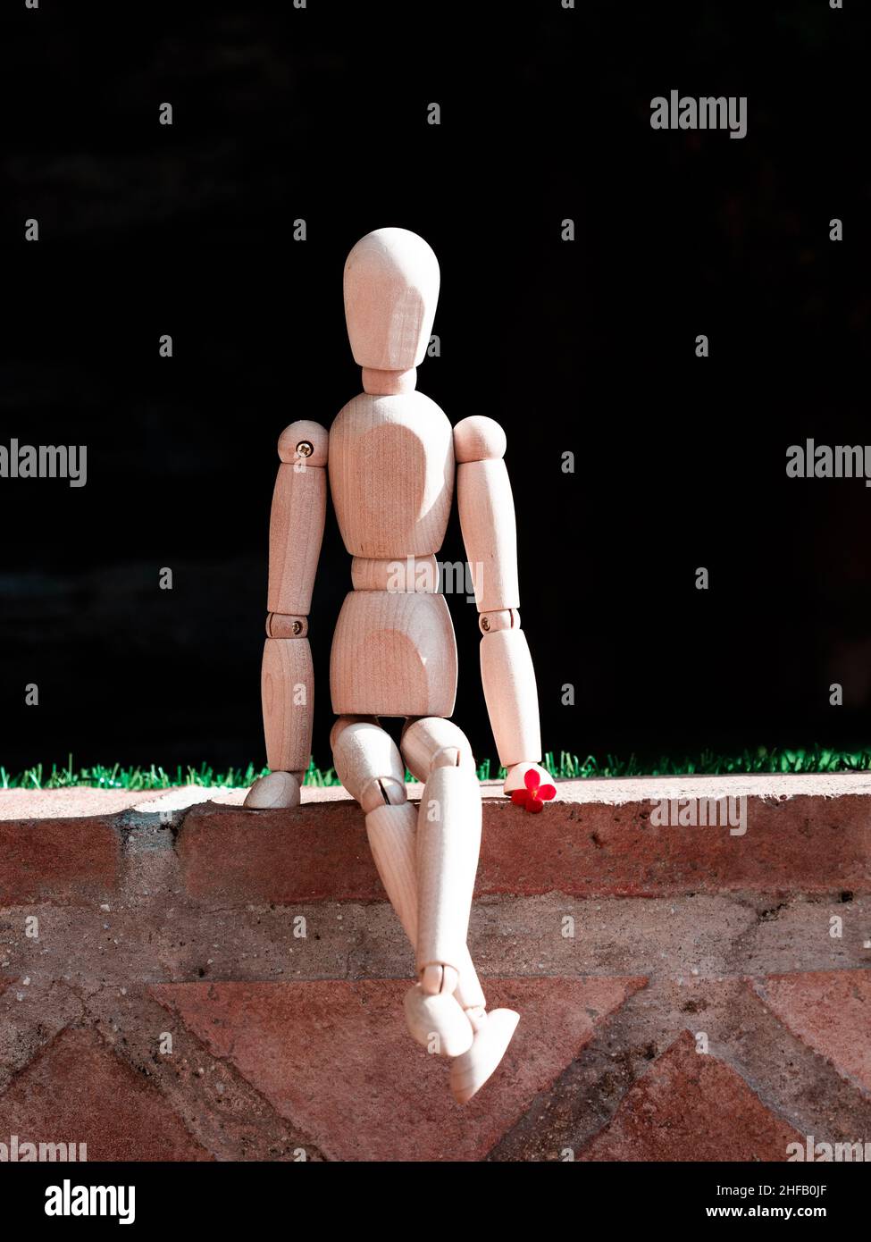 Bambola di legno umana seduta sul pavimento Foto Stock