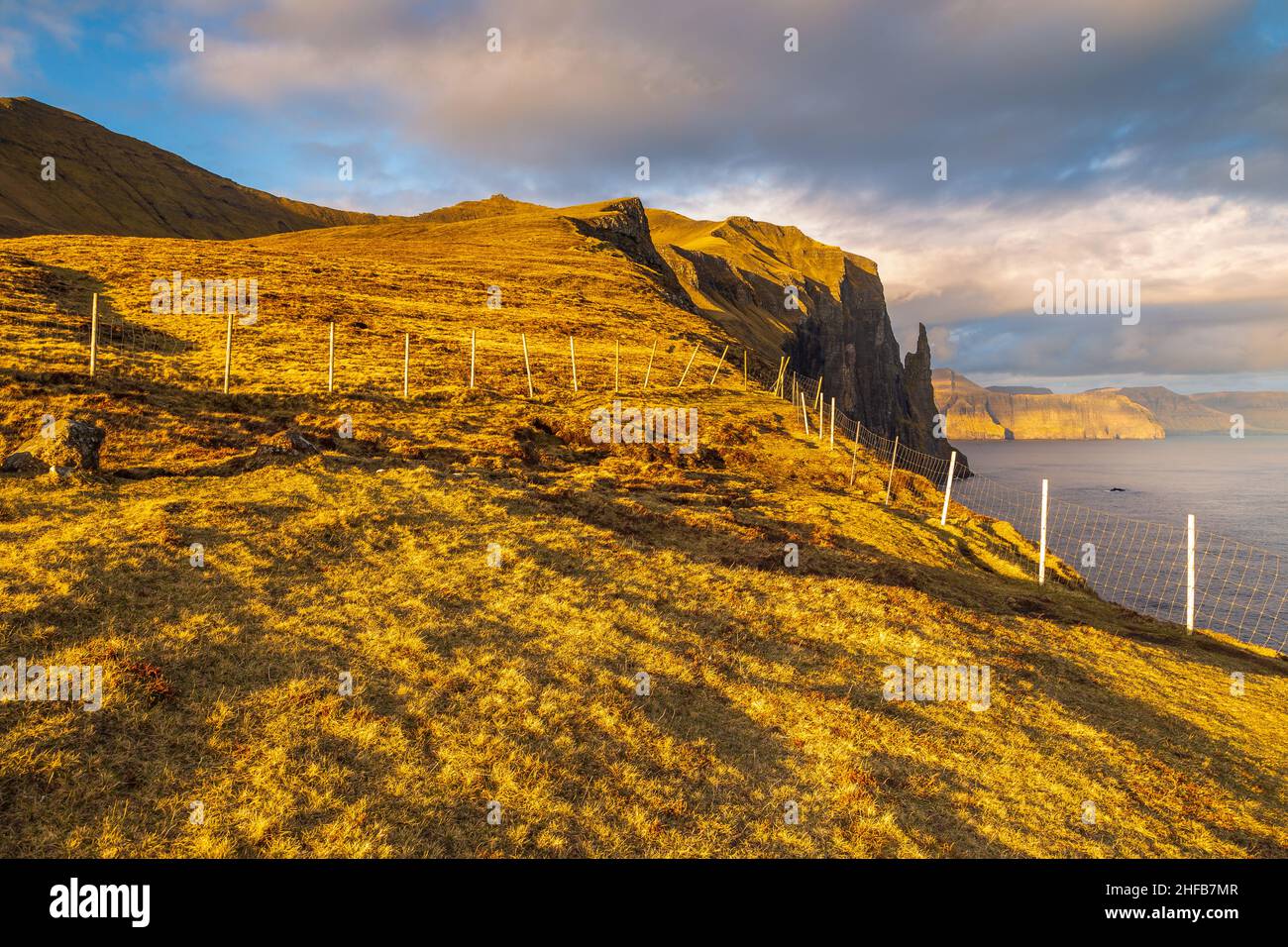 Witch Finger Rock sull'isola di Vagar alla luce del tramonto, Isole Faroe. Foto Stock
