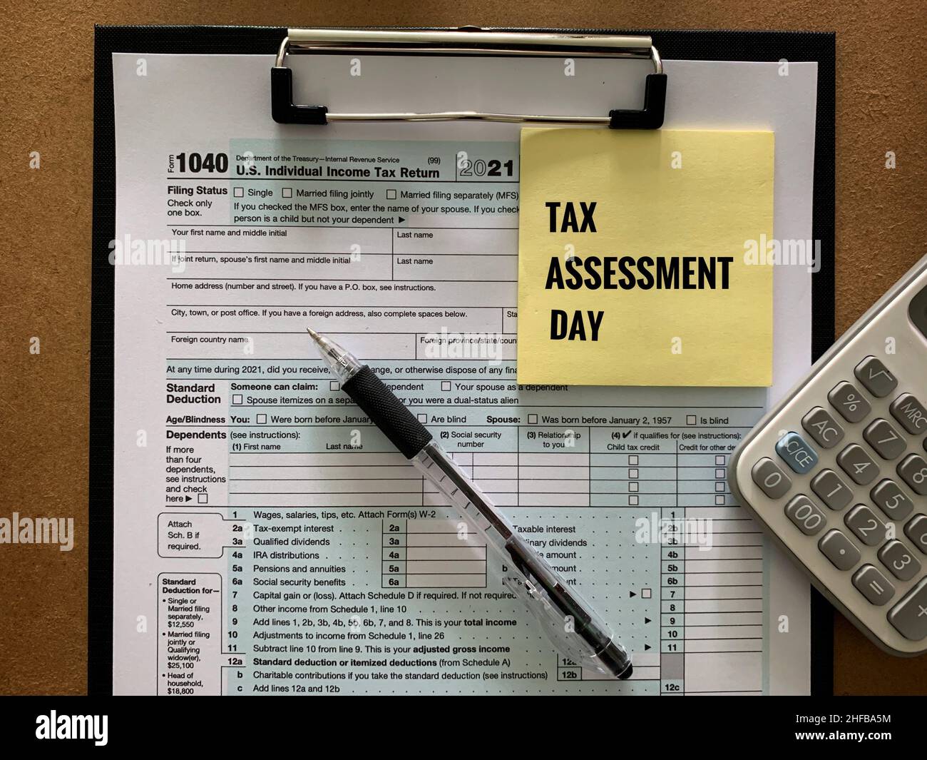 1040 modulo fiscale individuale USA, calcolatrice, penna e adesivo giallo. Concetto di imposta. Foto Stock