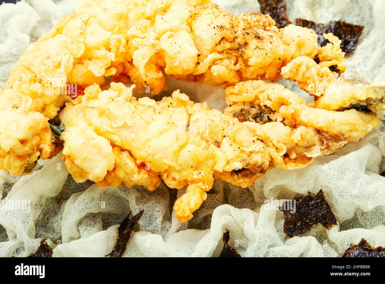 Pesce fritto di branzino con riso su carta di riso. Foto Stock