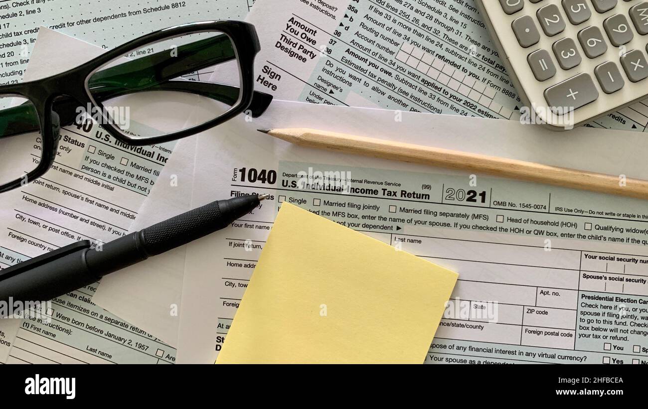 1040 US modulo fiscale individuale, penna, adesivo giallo, calcolatrice a matita e penna. Foto Stock