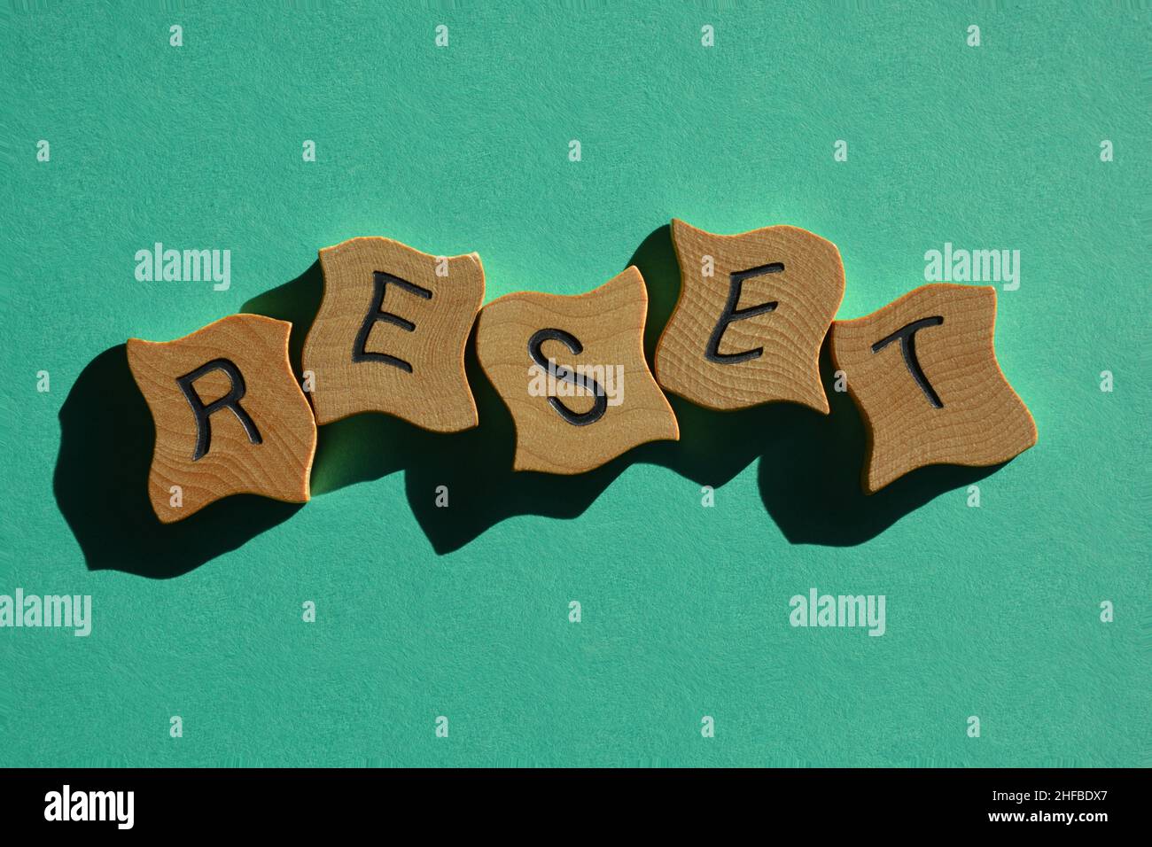 Reset, parola in lettere in legno lettera isolata su sfondo verde chiaro Foto Stock