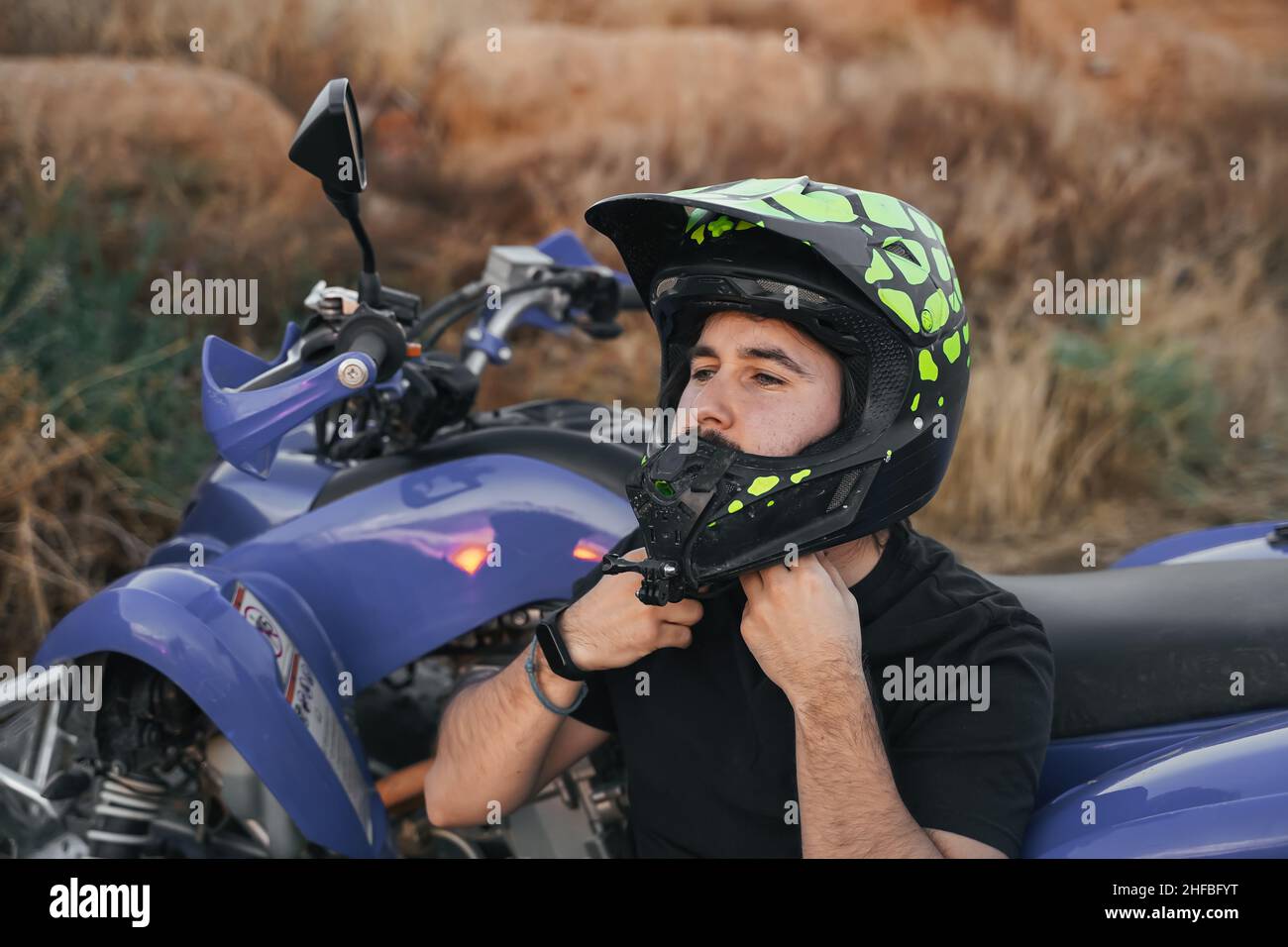 motociclista che mette sul casco Foto Stock