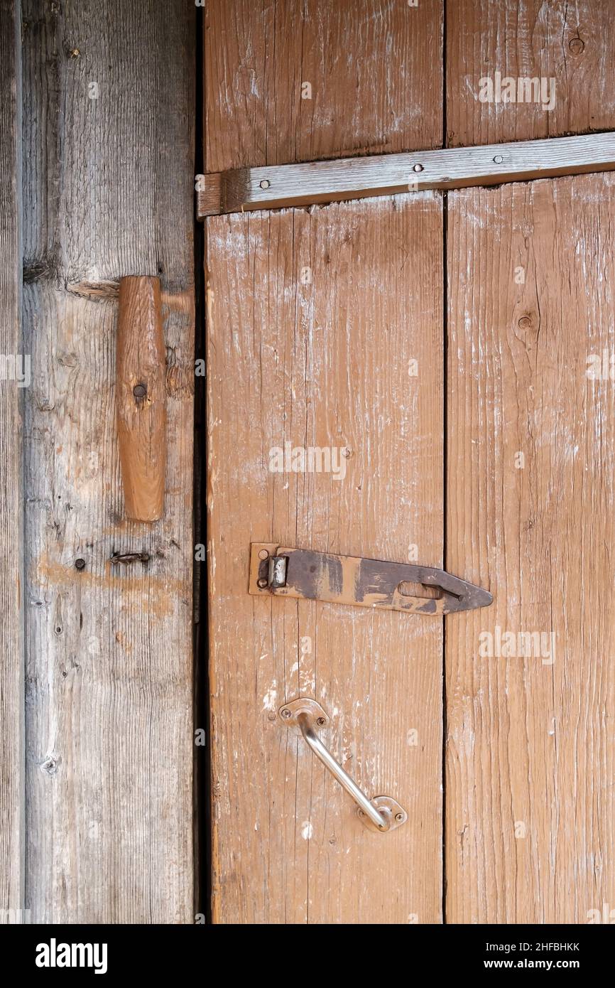 Serratura in legno e anello in lucchetto in metallo su sportello anteriore con plancia verniciata, all'aperto. Stile country. Foto Stock