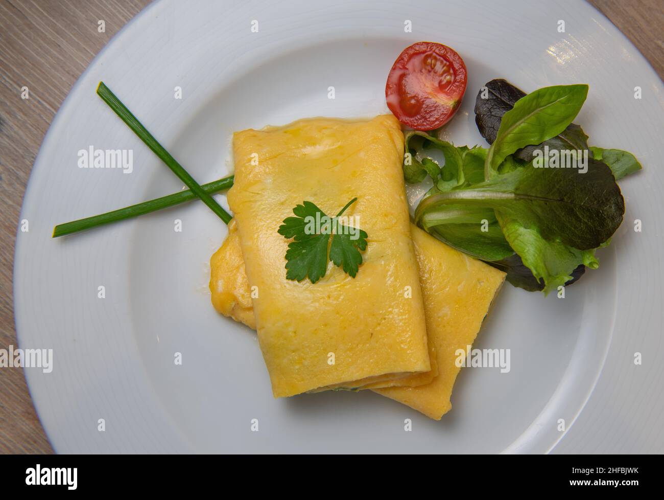 Omelette alle erbe con pomodoro, insalata e prezzemolo, colazione Foto Stock