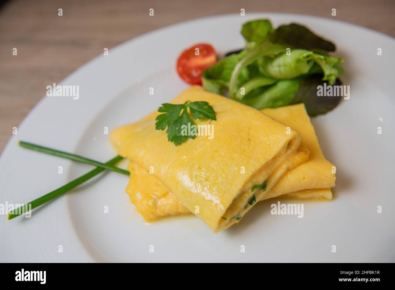 Omelette alle erbe con pomodoro, insalata e prezzemolo, colazione Foto Stock