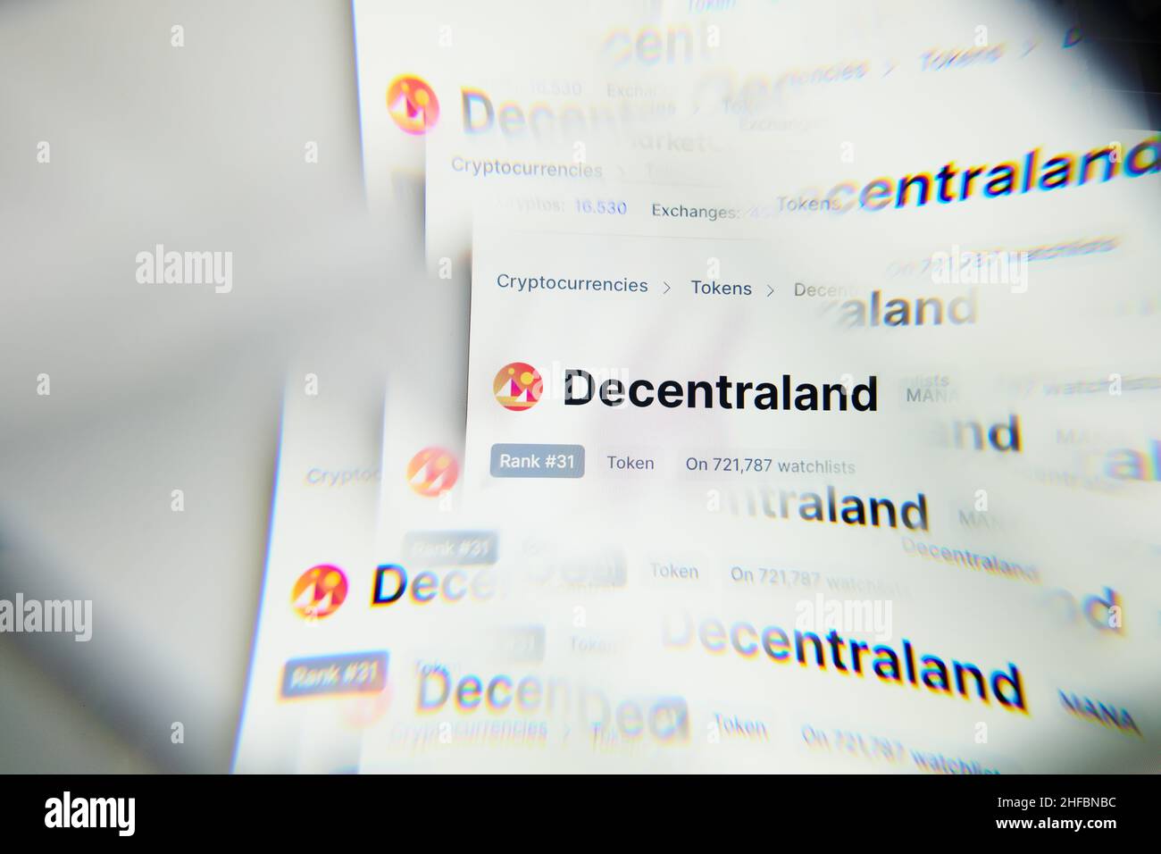 Milano, Italia - 11 gennaio 2022: Decentraland - logo MANA sullo schermo di un laptop visto attraverso un prisma ottico. Immagine dinamica e unica dal decentramento, Foto Stock