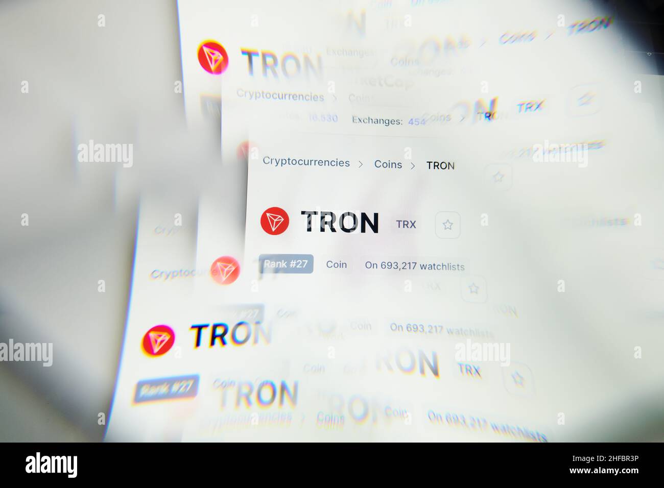 Milano, Italia - 11 gennaio 2022: tron - il logo TRX sullo schermo di un laptop visto attraverso un prisma ottico. Immagine dinamica ed unica forma tron, sito web TRX Coin. Foto Stock