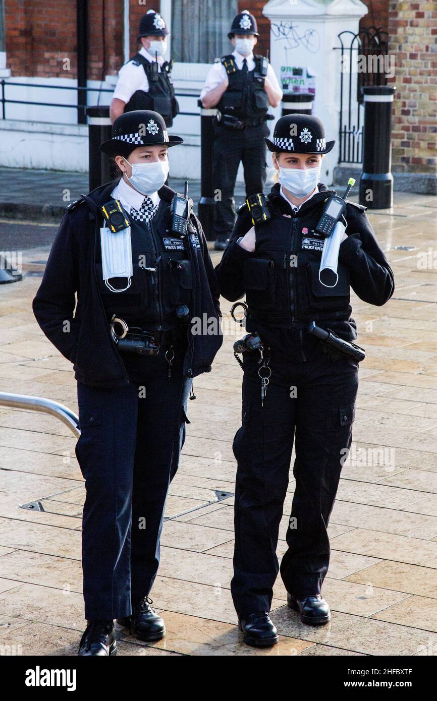 London UK 15th Jan, 2022 polizia indossare maschera guardare come i bambini che Hollding anti vacine cartelli cantare lungo la canzone 'on,t take the Vacine' a Brixton. Credit: Thabo Jaiyesimi/Alamy Live News Foto Stock
