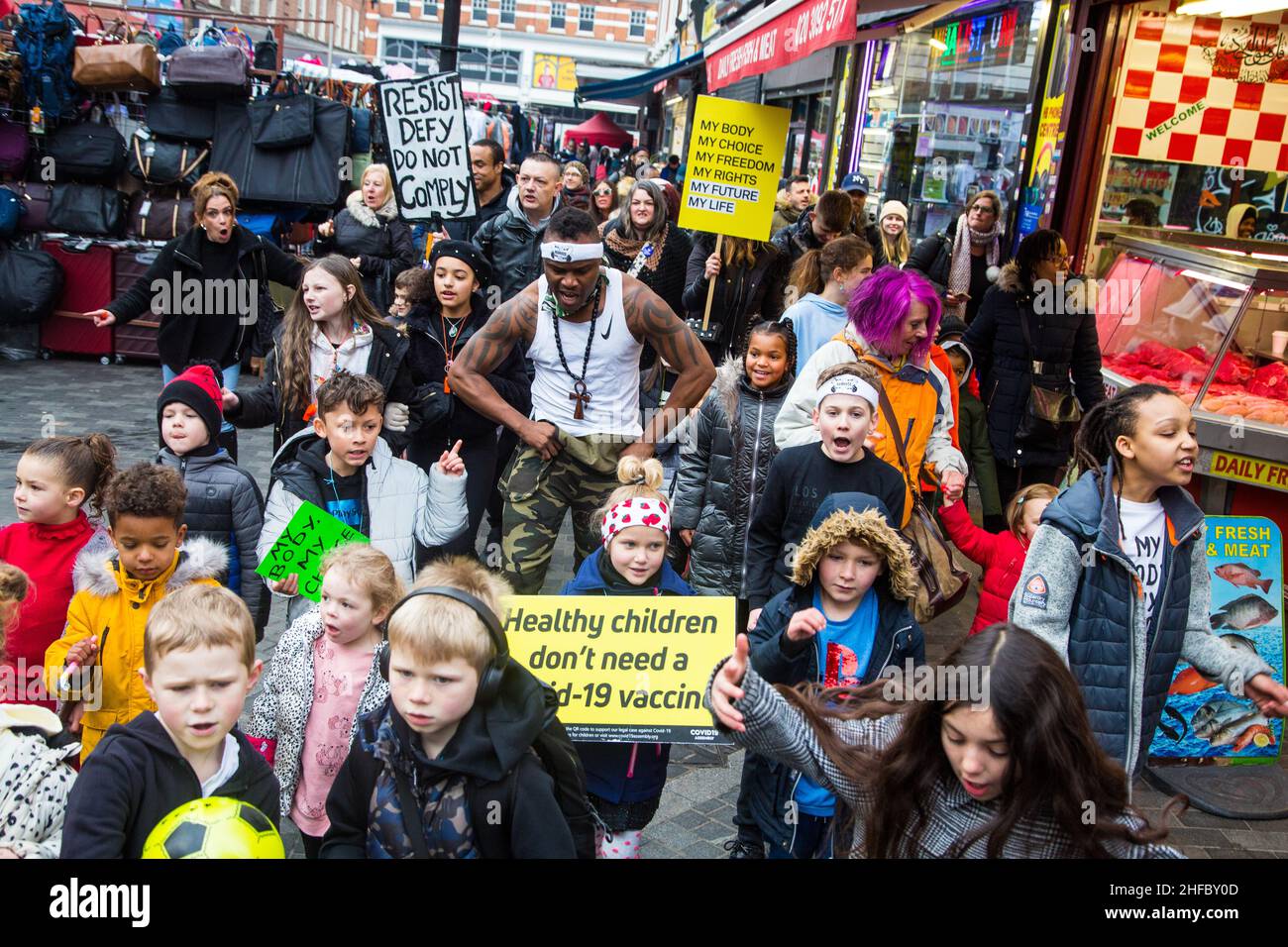 Londra,UK.15th Jan, 2022 Anti vacine attivista (c) canta come bambini in vacanza ant placards cantare lungo la canzone 'on,t take the Vacine' a Brixton. Credit: Thabo Jaiyesimi/Alamy Live News Foto Stock