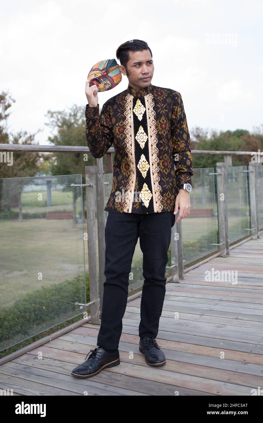 Un giovane modello maschile vestito in batik indonesiano con motivo  floreale balinese ospita una maschera giavanese al Long Museum, West Bund,  Shanghai Cina Foto stock - Alamy