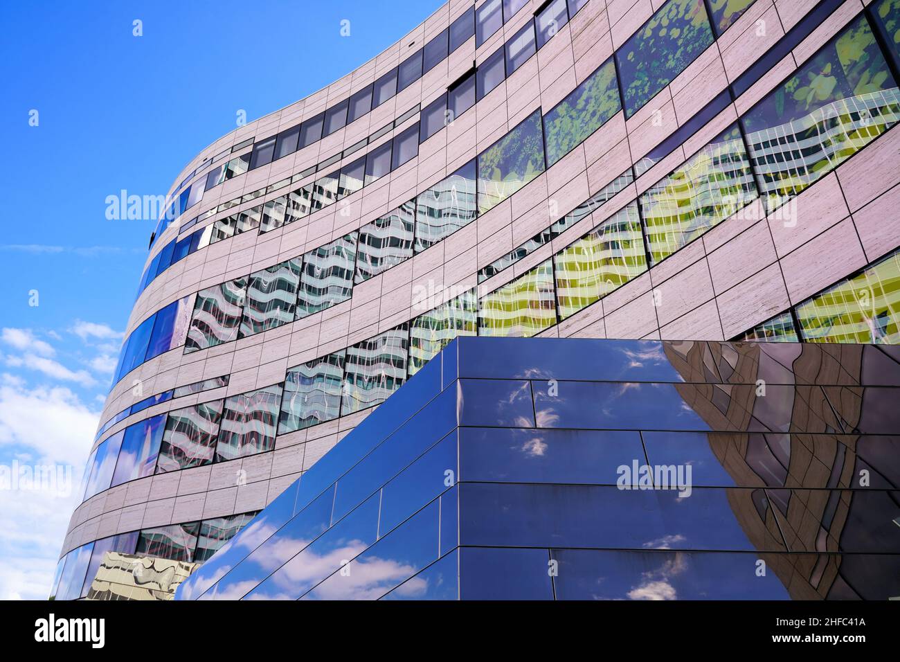 Edifici moderni a Kö-Bogen, progettati dal famoso architetto Daniel Libeskind di New York. Cielo blu e nuvole bianche che si riflettono nella facciata dell'edificio. Foto Stock