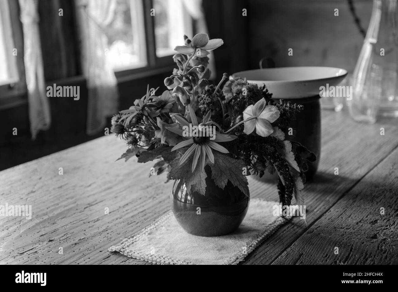 Blumenstrauss steht auf einem antiken Tisch in einem Haus des Freilichtmuses Ballenberg, Schweiz Foto Stock