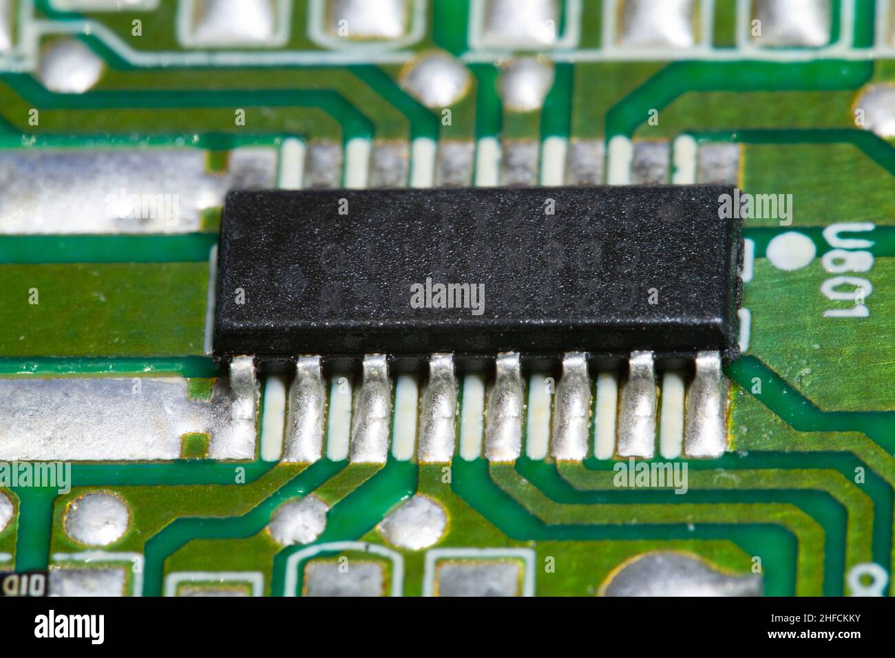 Microchip elettronico saldato su una scheda a circuito stampato (PCB) verde. Foto Stock