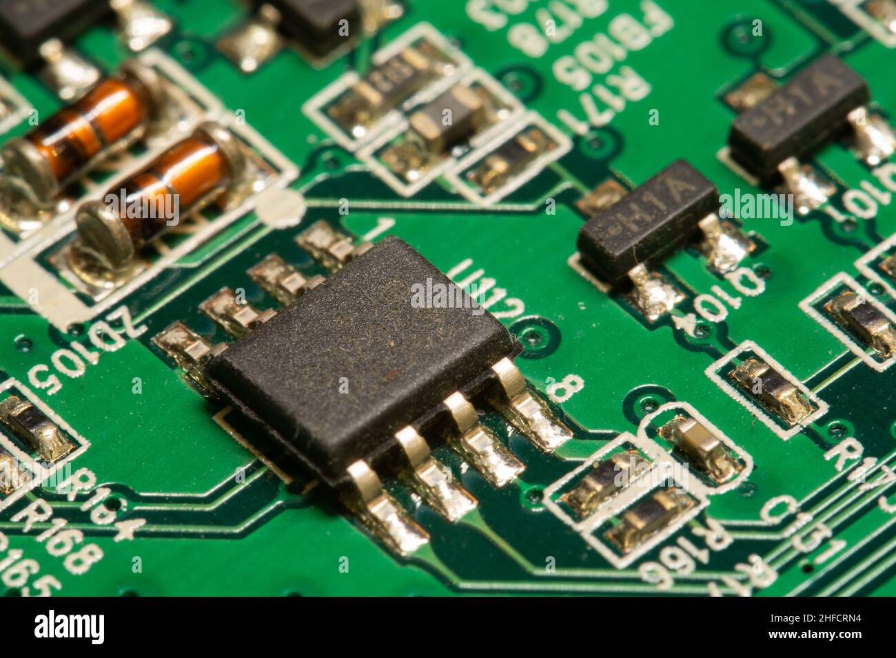 Microchip saldato su una scheda a circuito stampato (PCB) verde. Foto Stock