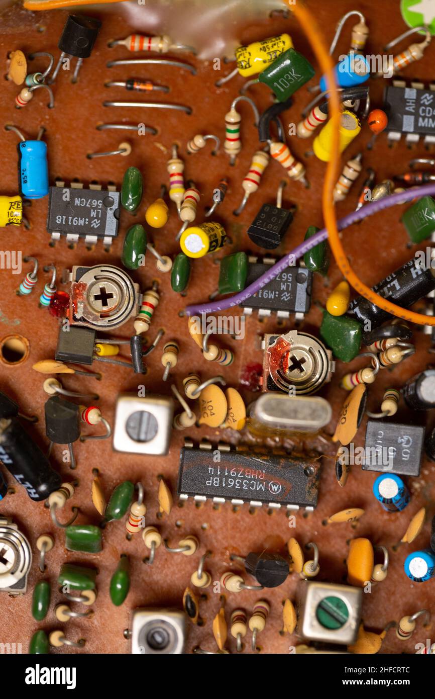 Vecchia scheda a circuito stampato con molti componenti elettronici. Foto Stock