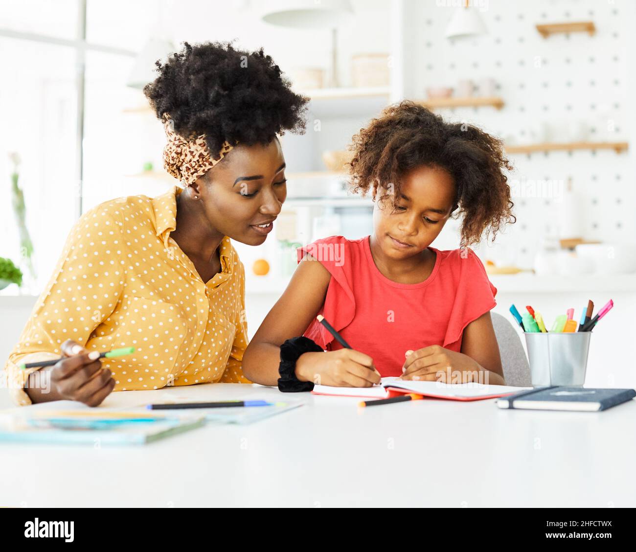 compiti di insegnamento istruzione madre figli figlia familiarità infanzia insegnante classe nero afroamericano Foto Stock