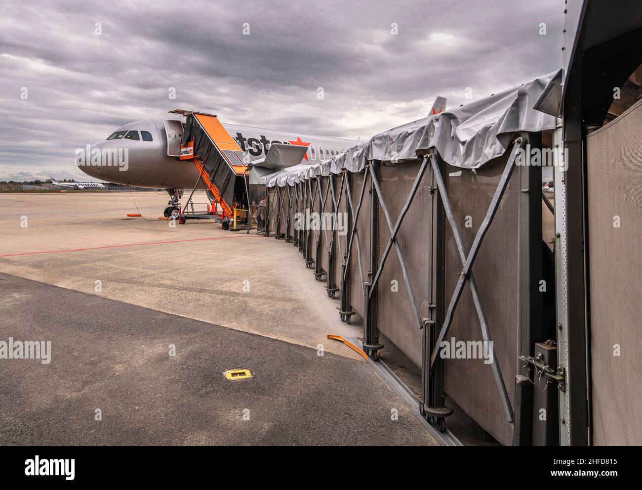 tokyo, giappone - dicembre 06 2021: Ponte jet boarding che conduce i passeggeri ad un aereo airbus da compagnia aerea giapponese low-cost jetstar Airways su t Foto Stock