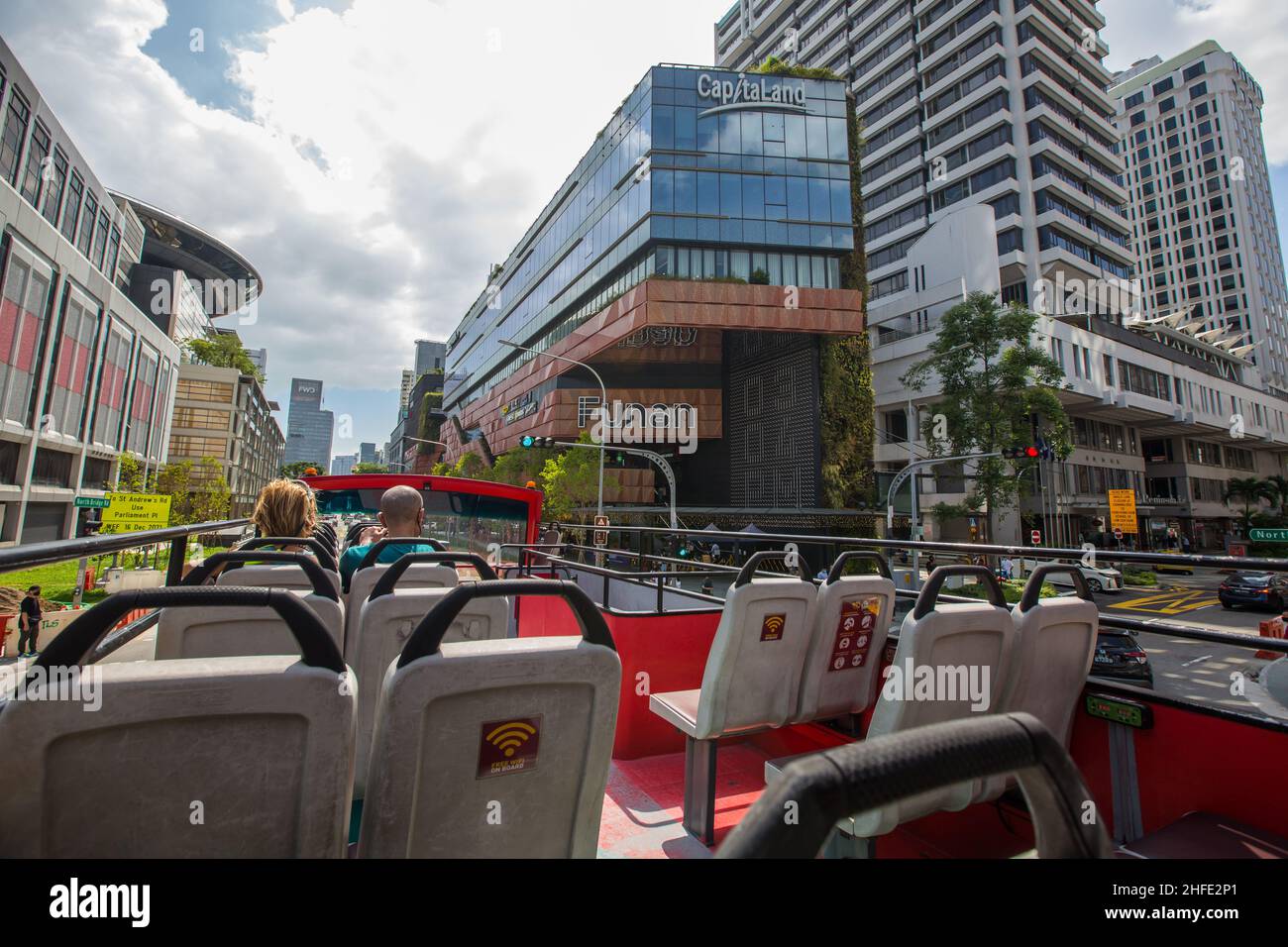 I viaggiatori che siedono su un autobus scoperto visitano l'area del Municipio di Singapore. Foto Stock