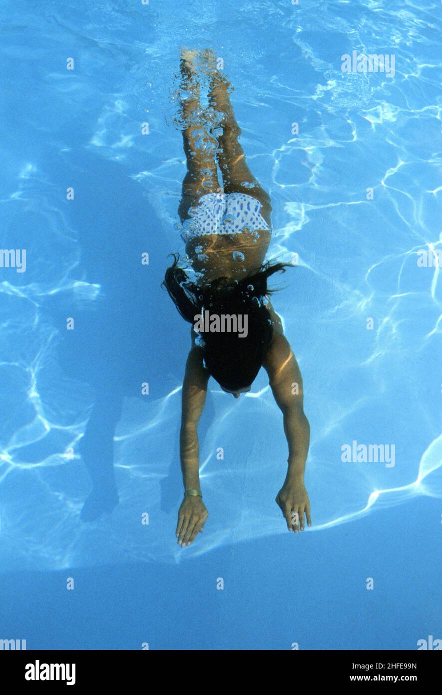 piscina giovane donna con capelli neri sotto l'acqua Foto Stock