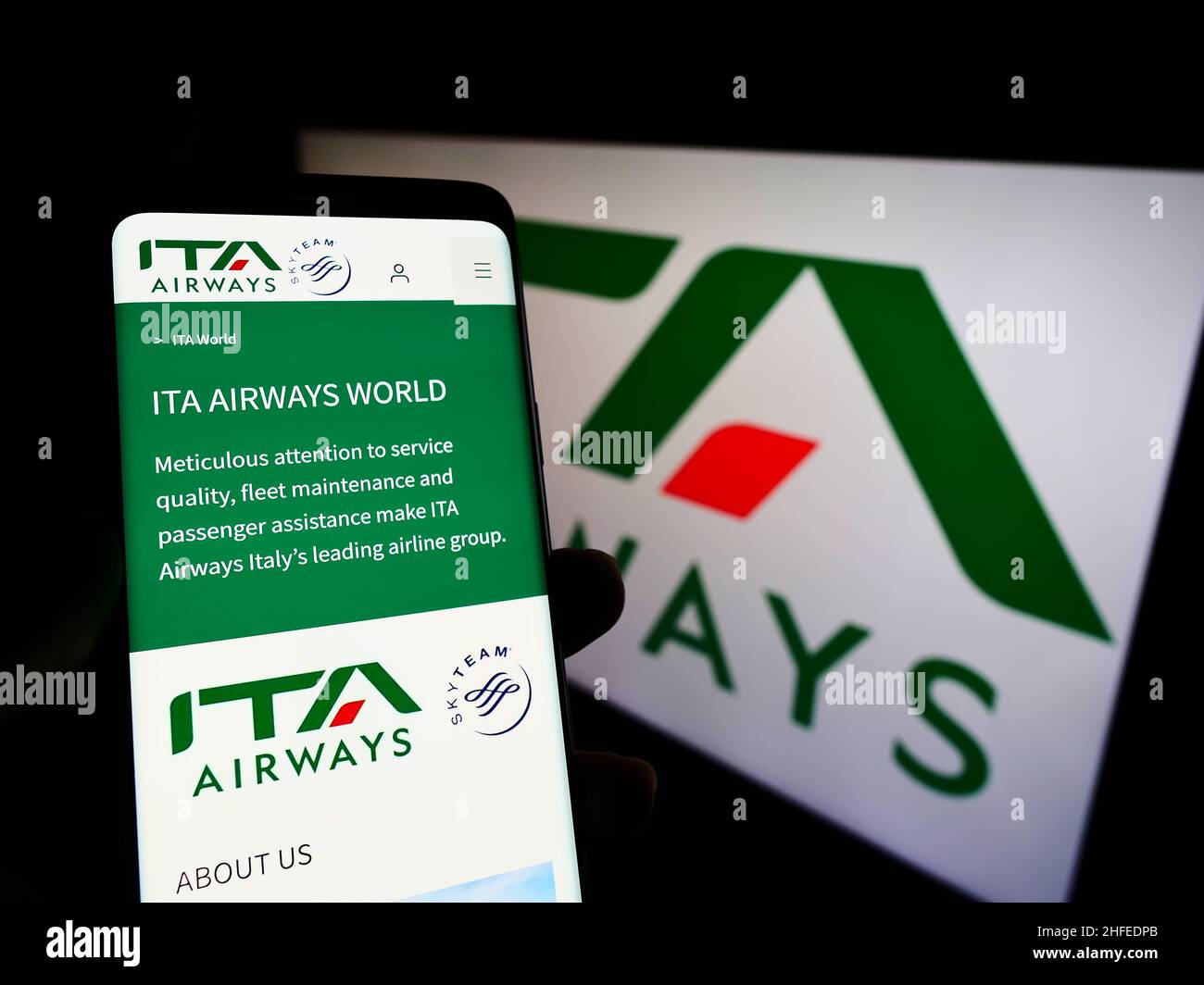 Persona che detiene il cellulare con il sito web della compagnia aerea Italia trasporto Aereo S.p.A. (ITA Airways) su schermo con logo. Concentrarsi sul centro del display del telefono. Foto Stock