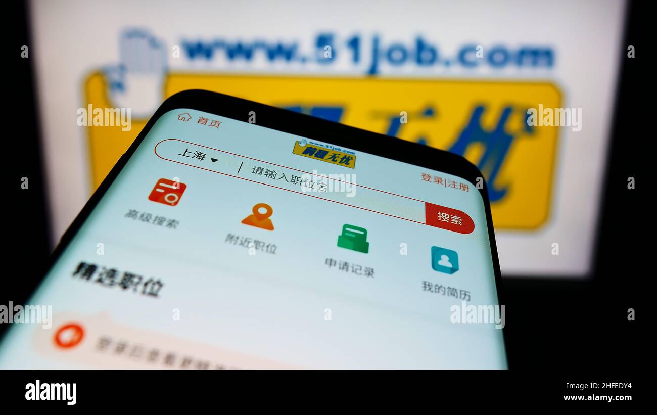 Smartphone con pagina Web della società cinese di risorse umane 51job Inc. Sullo schermo di fronte al logo aziendale. Mettere a fuoco sulla parte superiore sinistra del display del telefono. Foto Stock