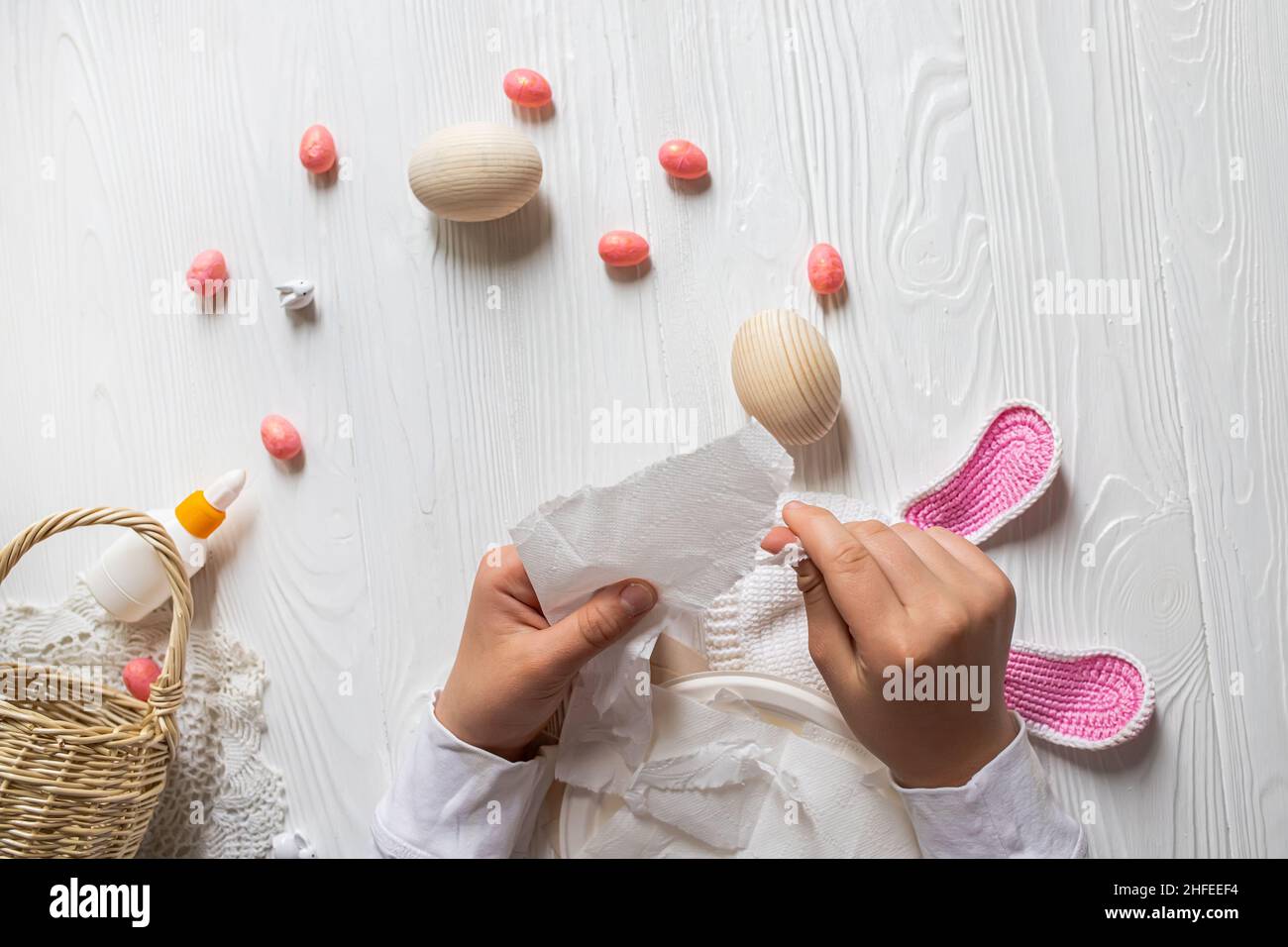 Idee fai da te per creare un arredamento di Pasqua. Istruzioni passo per passo per preparare le uova da papier mache. Passo 4 mani strappare tovagliolo di carta in pezzi per s Foto Stock