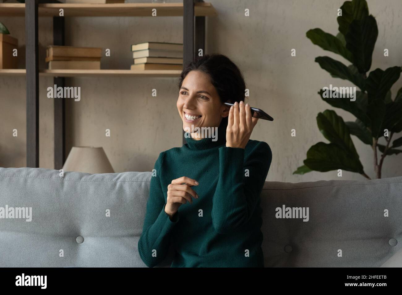 Donna felice ascolto audio messaggio sul cellulare. Foto Stock