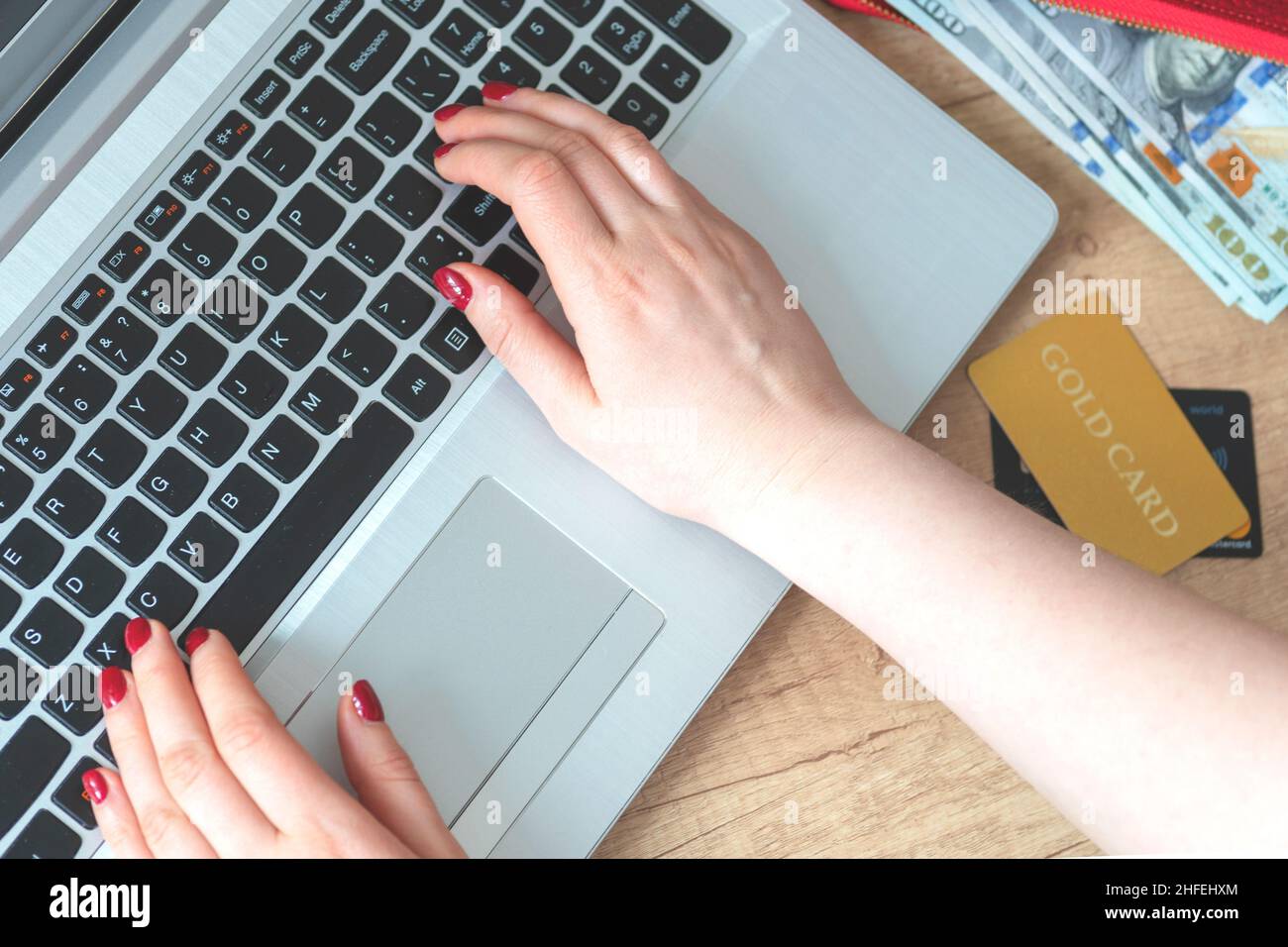 Mani sul laptop background.Hands, portafoglio, soldi, laptop, carta d'oro, concetto di carte scegliere e acquistare merci online. Shopper. Concetto di shopping online, vendita Foto Stock