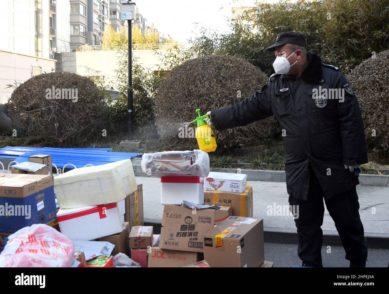 Pechino, Cina. 16th Jan 2022. Un membro del personale disinfetta i pacchi da consegnare ai residenti in una zona residenziale nel distretto di Haidian di Pechino, capitale della Cina, 16 gennaio 2022. Pechino ha segnalato un nuovo caso COVID-19 trasmesso localmente Sabato, autorità sanitaria locale ha detto. La comunità in cui vive il caso comfired è sotto la gestione ravvicinata. Credit: Ren Chao/Xinhua/Alamy Live News Foto Stock