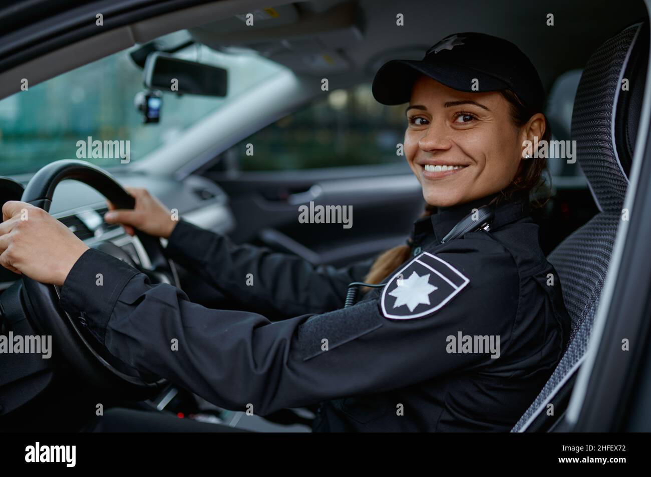 Vista laterale ritratto polizia donna guida auto Foto Stock