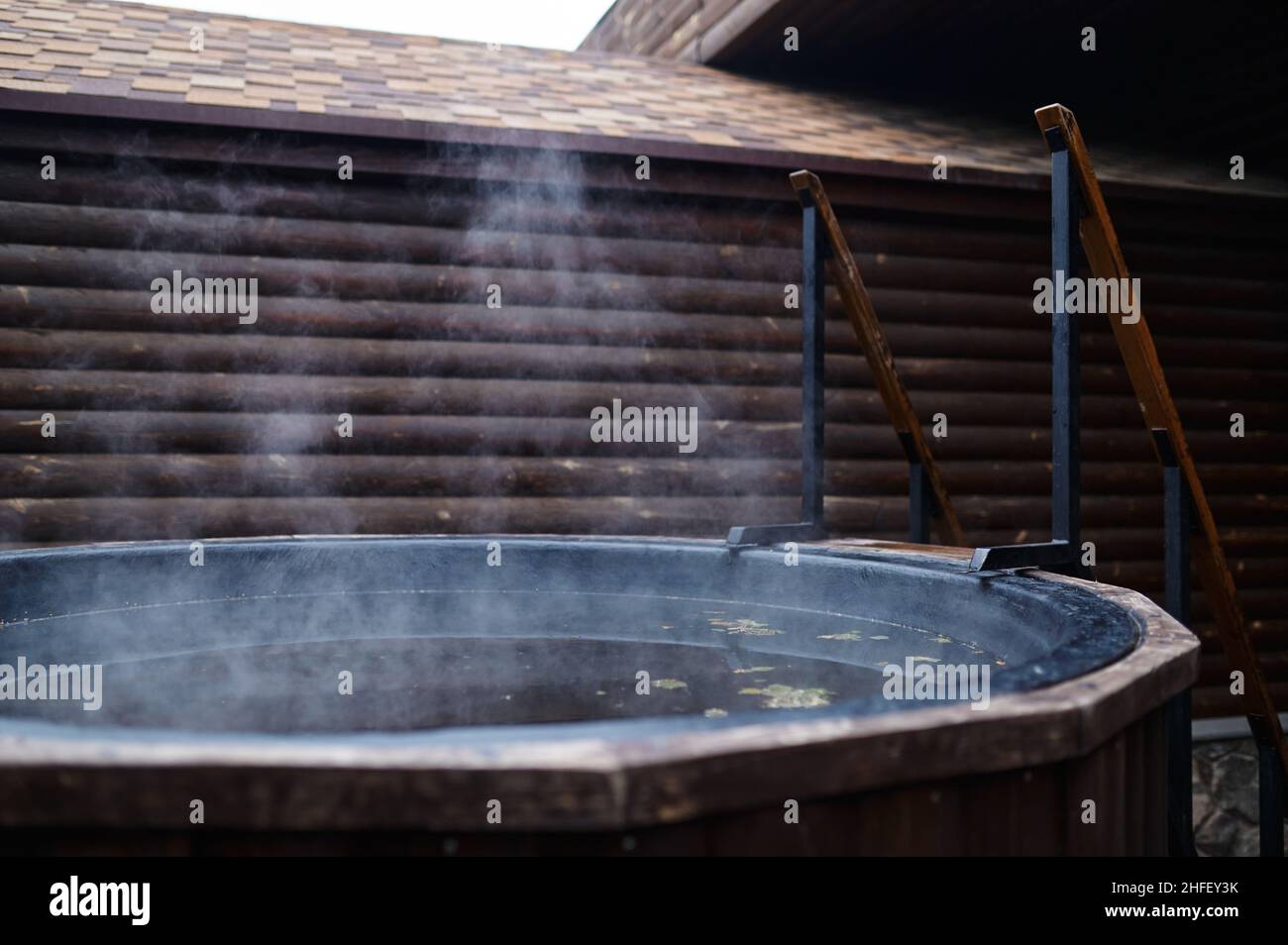 Vasca da bagno in legno con piano cottura sulla terrazza esterna Foto Stock